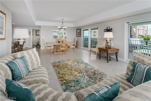 tiled living room with a tray ceiling, a chandelier, and a wealth of natural light