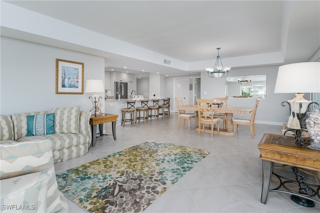 tiled living room featuring an inviting chandelier and sink