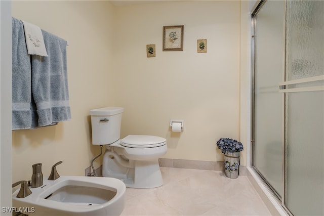 bathroom featuring tile patterned floors, a bidet, a shower with shower door, and toilet