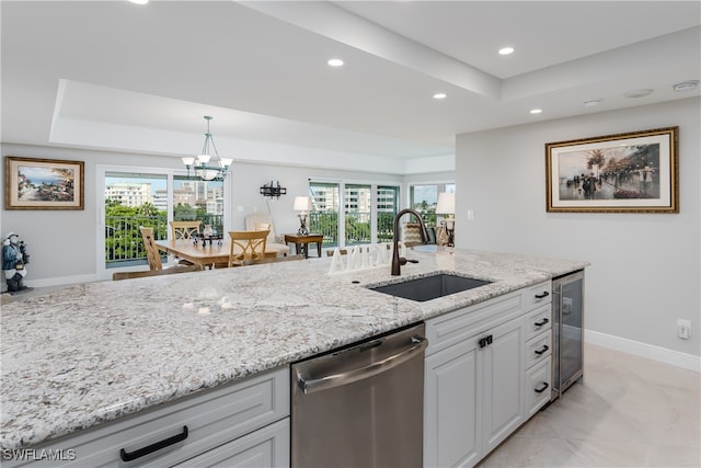 kitchen with pendant lighting, sink, stainless steel dishwasher, a chandelier, and white cabinetry