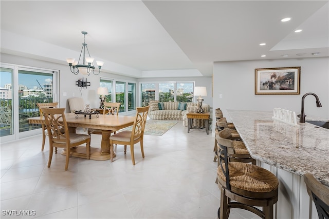 dining space with sink, a chandelier, and a healthy amount of sunlight