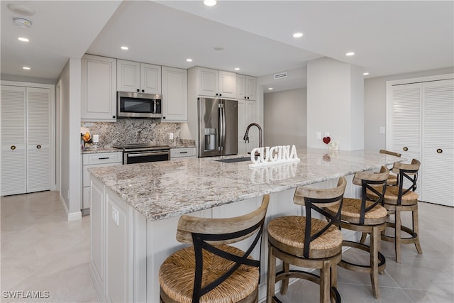 kitchen with white cabinets, stainless steel appliances, and a spacious island