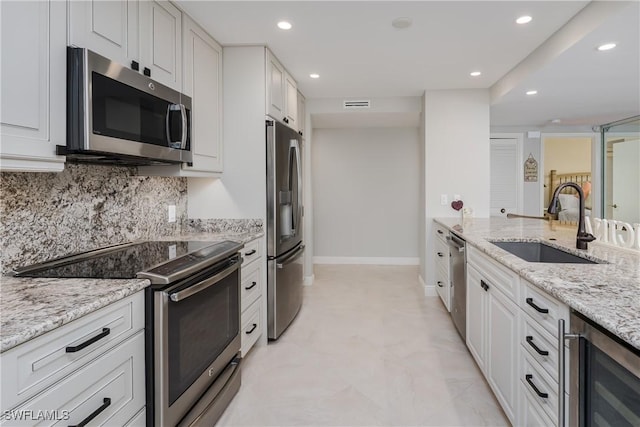1036 S Collier Blvd Unit B-301, Marco Island, FL 34145 - kitchen featuring stainless steel appliances, beverage cooler, a sink, recessed lighting, and light stone countertops