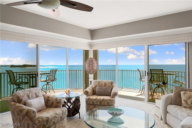 sunroom / solarium featuring ceiling fan and a water view