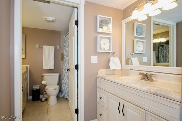 bathroom featuring tile patterned flooring, vanity, and toilet