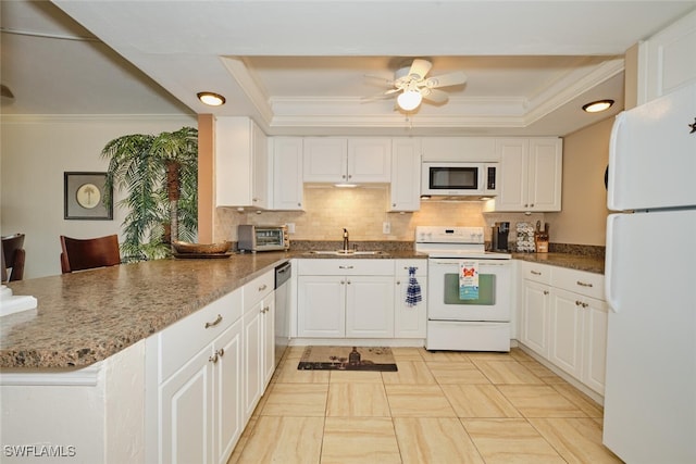 kitchen featuring a sink, ornamental molding, a peninsula, and white appliances