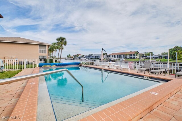 pool with fence and a patio