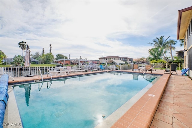 pool with fence and a patio area