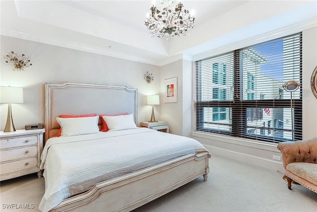 bedroom with ornamental molding, carpet, a notable chandelier, and a tray ceiling