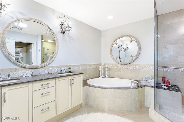 bathroom with vanity, a relaxing tiled tub, and tile patterned floors