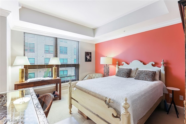 carpeted bedroom with crown molding and a tray ceiling