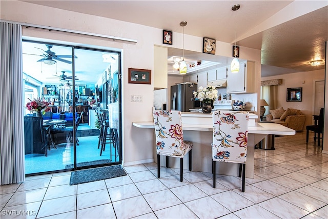 kitchen with kitchen peninsula, a kitchen breakfast bar, pendant lighting, white cabinets, and stainless steel fridge with ice dispenser