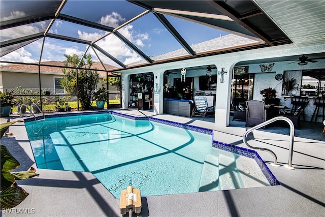 view of swimming pool featuring a patio area, ceiling fan, and glass enclosure