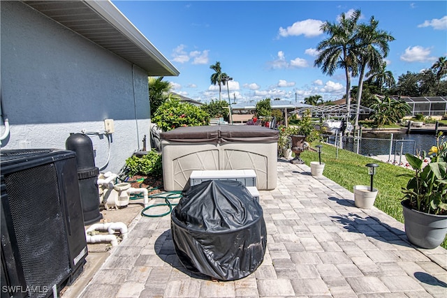 view of patio featuring a water view, a hot tub, and cooling unit