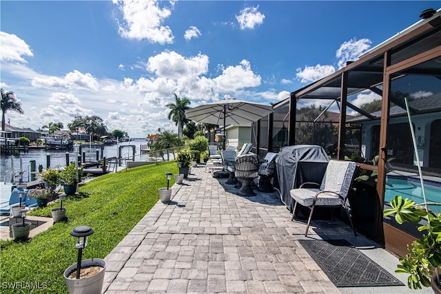 view of patio featuring a dock, a water view, and glass enclosure