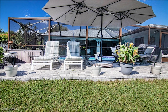 view of patio with an outdoor fire pit and glass enclosure