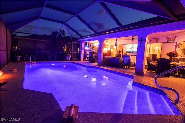 view of pool with ceiling fan, a patio, and a lanai