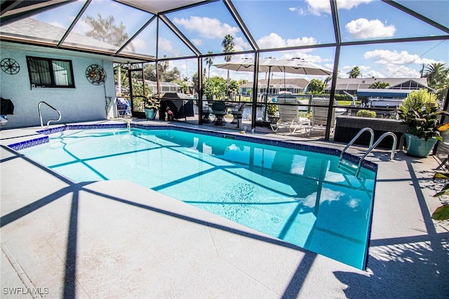 view of pool with a patio area and glass enclosure