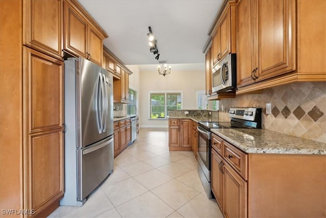15621 Red Fox Run, Fort Myers, FL 33912 - kitchen with appliances with stainless steel finishes, brown cabinetry, and tasteful backsplash
