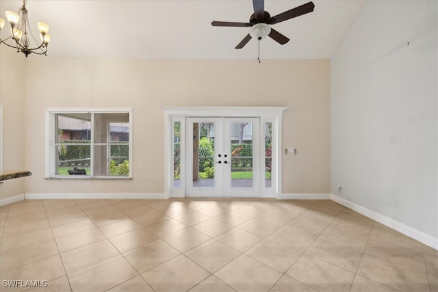 unfurnished living room with french doors, vaulted ceiling, ceiling fan with notable chandelier, and light tile patterned floors