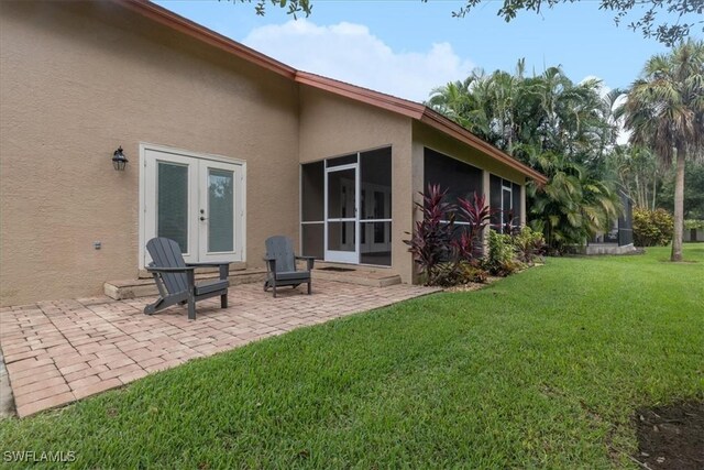 15621 Red Fox Run, Fort Myers, FL 33912 - rear view of house with stucco siding, french doors, a patio area, a yard, and a sunroom