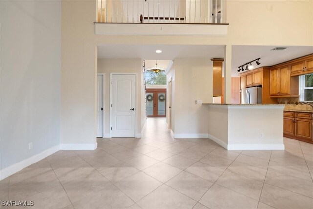 15621 Red Fox Run, Fort Myers, FL 33912 - kitchen featuring freestanding refrigerator, light tile patterned flooring, healthy amount of natural light, and a towering ceiling