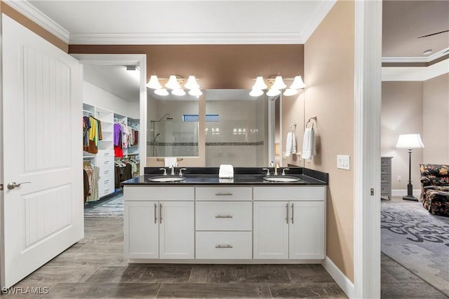 12917 Hadley Ct, Fort Myers, FL 33913 - ensuite bathroom featuring double vanity, crown molding, tiled shower, a spacious closet, and baseboards