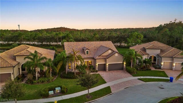 12917 Hadley Ct, Fort Myers, FL 33913 - mediterranean / spanish-style house featuring driveway, a garage, and stucco siding