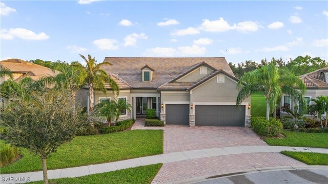 12917 Hadley Ct, Fort Myers, FL 33913 - view of front facade with stucco siding, a front yard, decorative driveway, and a garage
