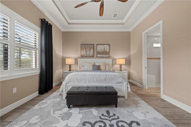 12917 Hadley Ct, Fort Myers, FL 33913 - bedroom featuring a tray ceiling, wood finished floors, ornamental molding, baseboards, and ensuite bath