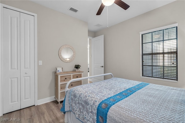 bedroom with ceiling fan, light hardwood / wood-style flooring, and a closet