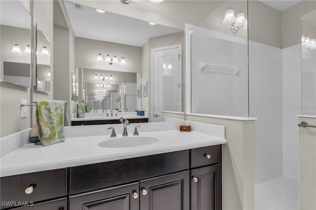 bathroom with tiled shower and vanity