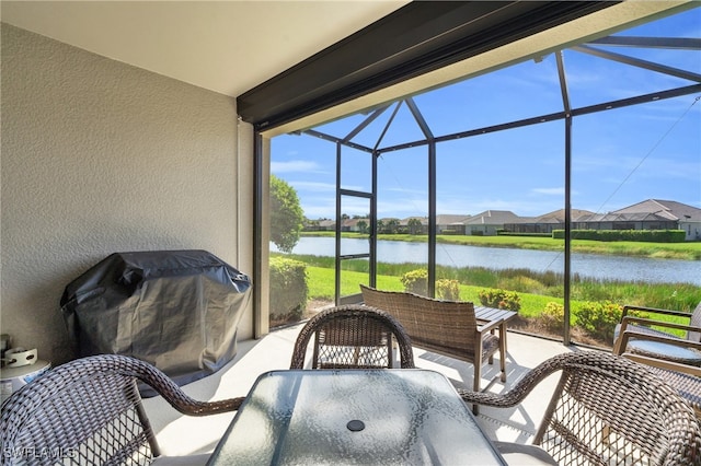 view of patio with a lanai, a water view, and area for grilling