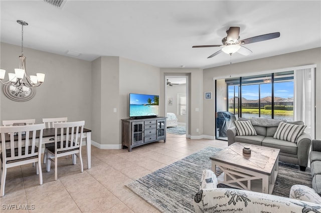 tiled living room featuring ceiling fan with notable chandelier