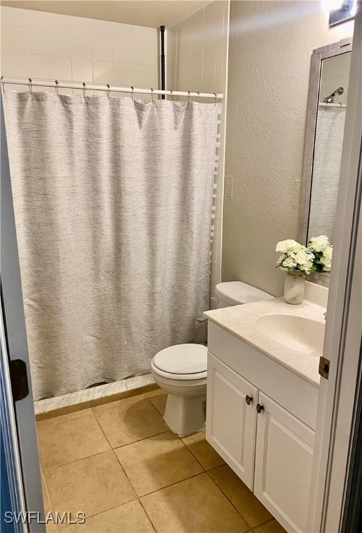 bathroom with curtained shower, vanity, toilet, and tile patterned floors