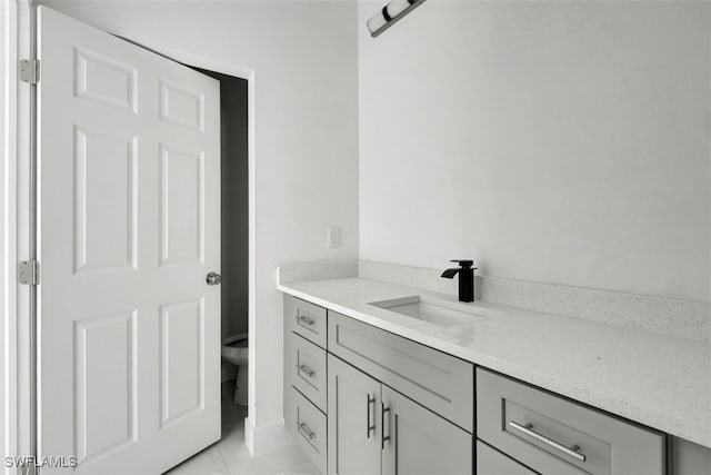 bathroom featuring tile patterned flooring, vanity, and toilet