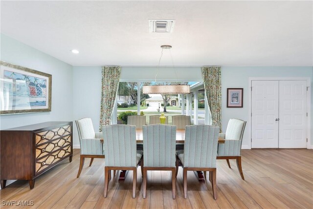 dining space featuring light wood-type flooring and a chandelier