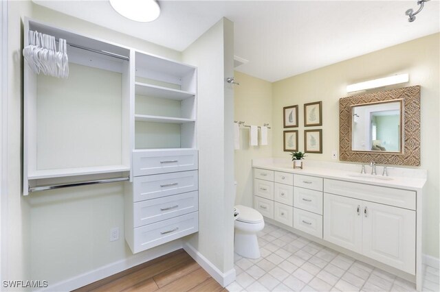 bathroom featuring wood-type flooring, vanity, and toilet