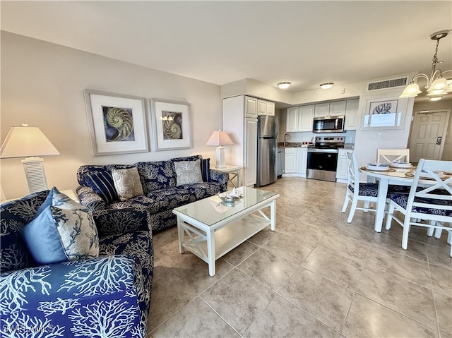 living room with a notable chandelier, sink, and light tile patterned floors