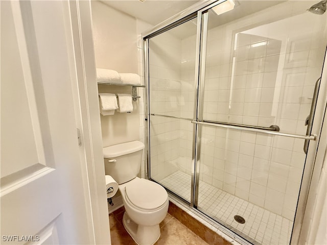 bathroom with tile patterned floors, an enclosed shower, and toilet