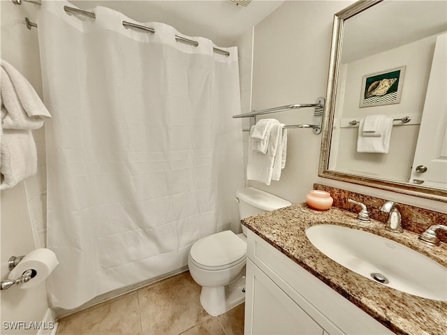 bathroom with curtained shower, vanity, toilet, and tile patterned floors