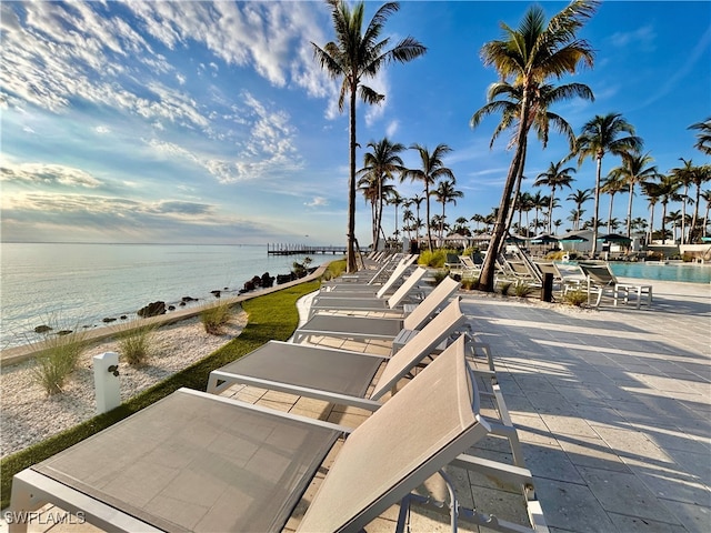 view of home's community with a water view, a patio area, and a pool