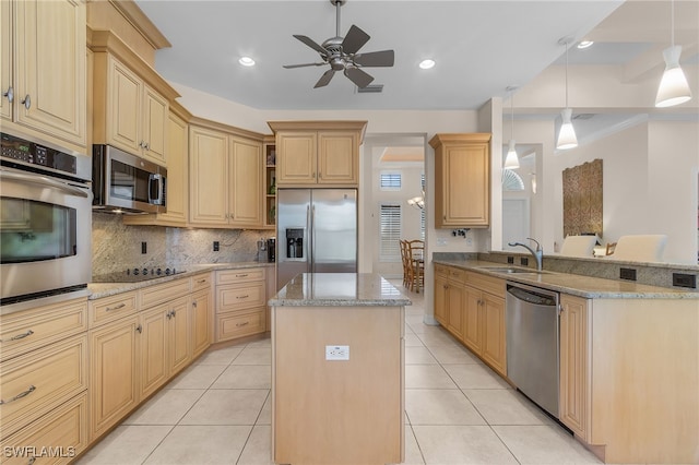 kitchen featuring ceiling fan, light stone counters, kitchen peninsula, a kitchen island, and stainless steel appliances