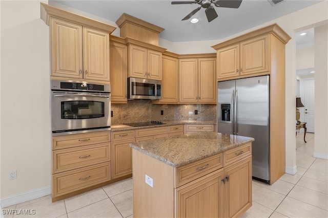 kitchen with tasteful backsplash, a kitchen island, appliances with stainless steel finishes, light stone countertops, and ceiling fan