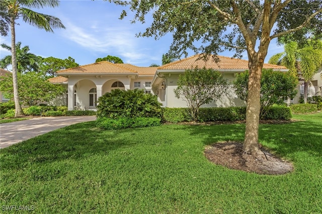 mediterranean / spanish-style home featuring a front yard