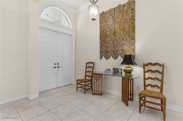 foyer featuring light tile patterned flooring, baseboards, and ornamental molding