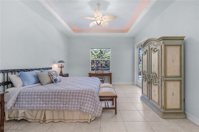 tiled bedroom featuring ornamental molding, a tray ceiling, and ceiling fan