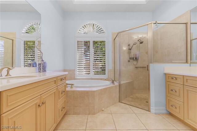 bathroom featuring independent shower and bath, plenty of natural light, and vanity