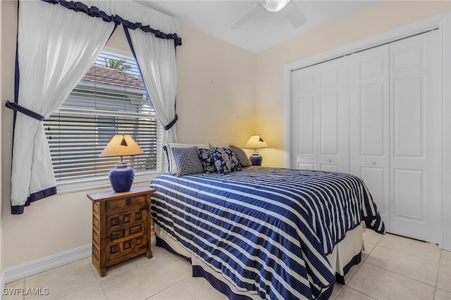 bedroom with light tile patterned flooring, ceiling fan, and a closet