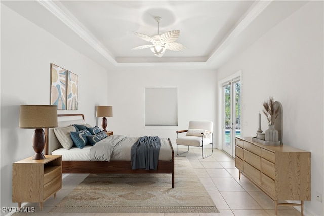 bedroom with access to exterior, a tray ceiling, light tile patterned floors, and a ceiling fan